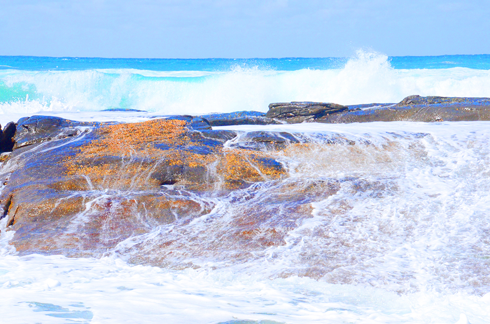 OCEAN WASHING ACROSS ROCKS.